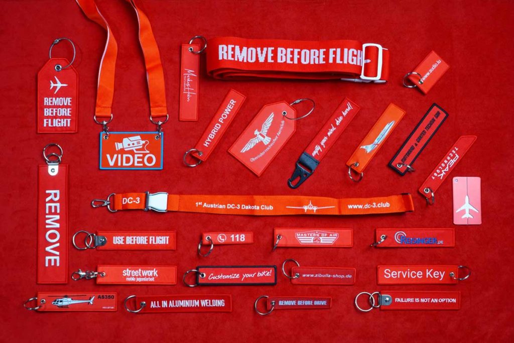 Rote Werbeartikel wie Schlüsselanhänger, Lanyards, Kofferbänder